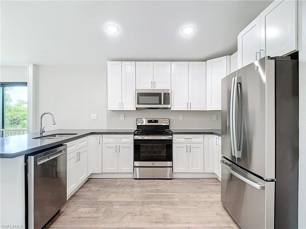 2505 Storter Avenue Naples, FL 34112 - Photo 14 of 49 a kitchen with granite countertop a refrigerator stove and sink