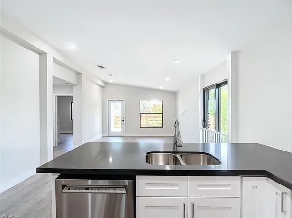 a kitchen with granite countertop a sink window and cabinets