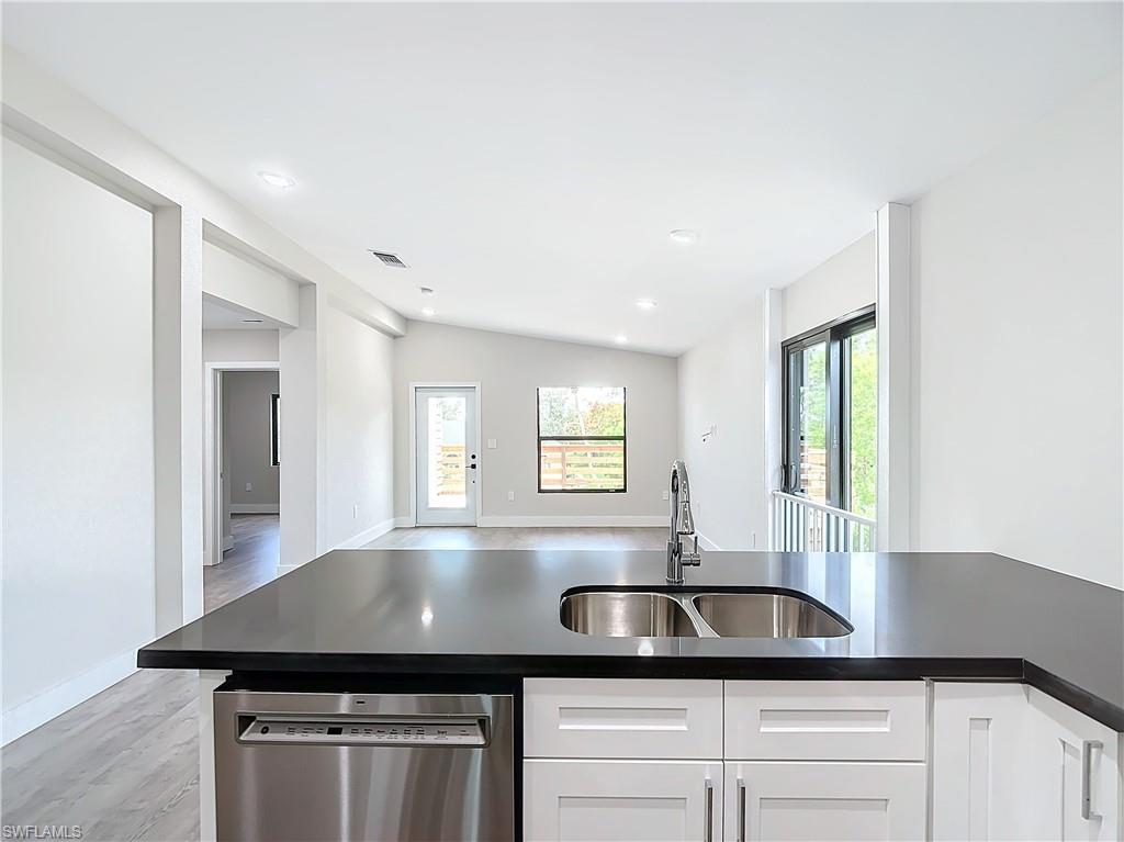 2505 Storter Avenue Naples, FL 34112 - Photo 16 of 49 a kitchen with granite countertop a sink window and cabinets
