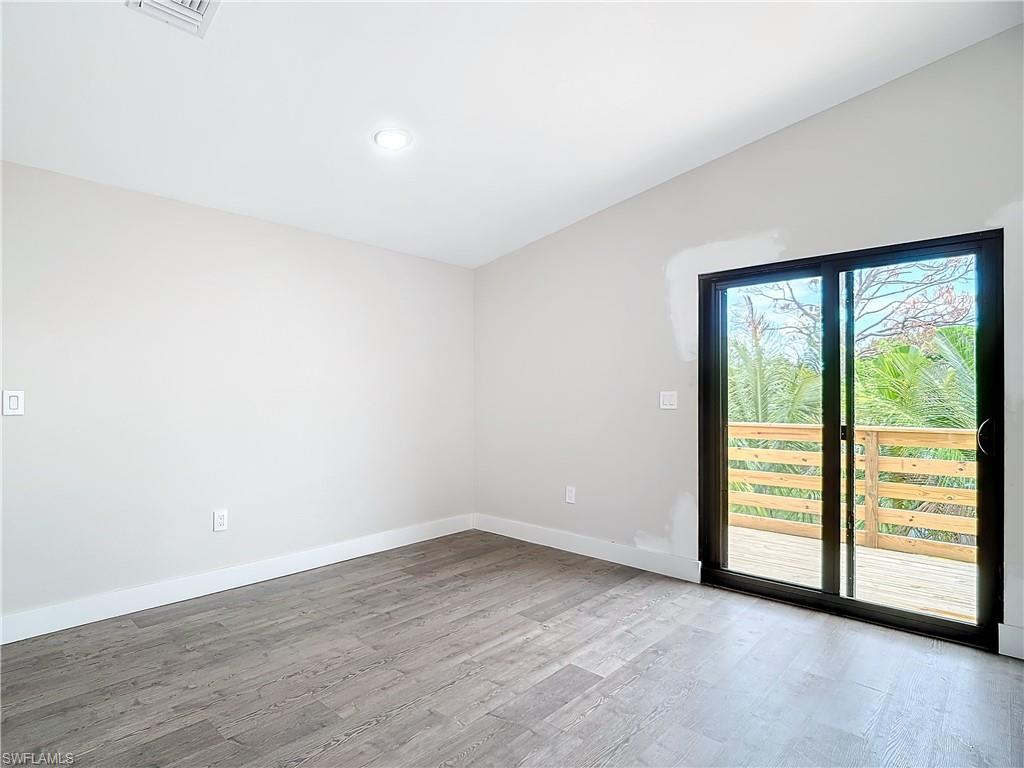 2505 Storter Avenue Naples, FL 34112 - Photo 17 of 49 an empty room with wooden floor and windows