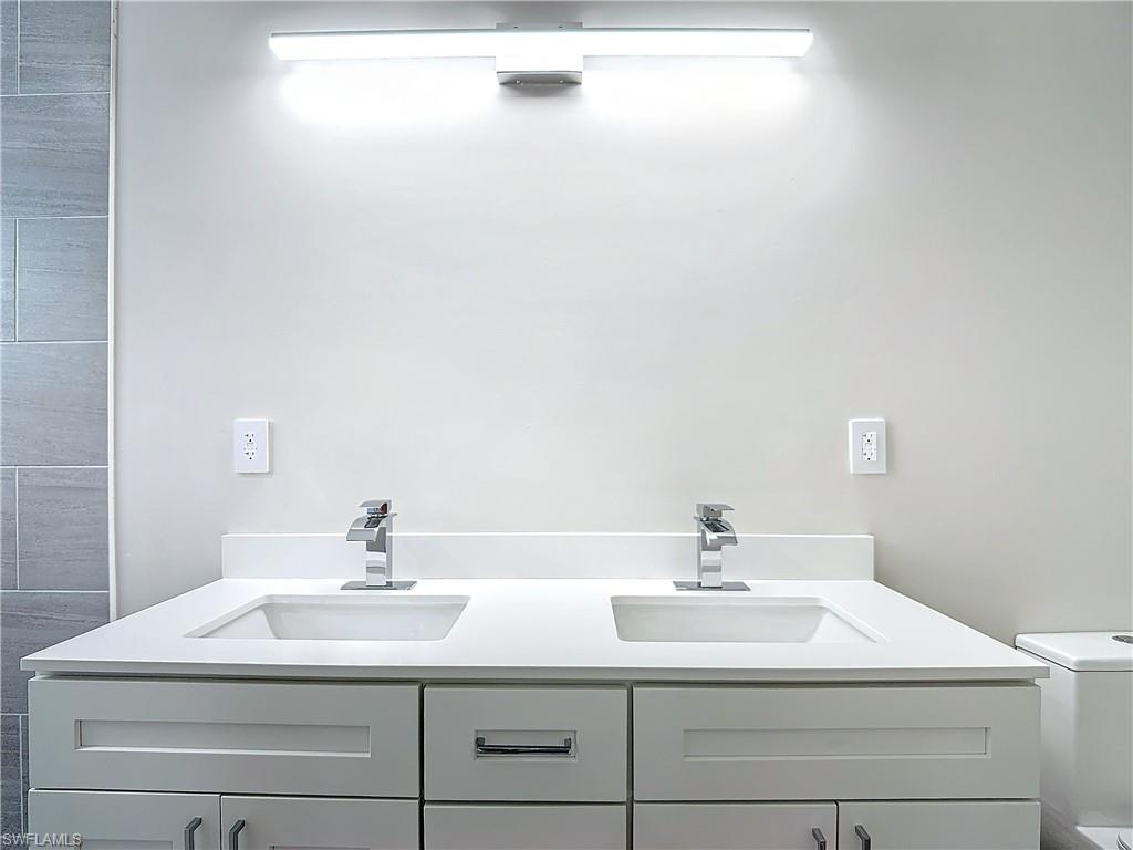 2505 Storter Avenue Naples, FL 34112 - Photo 26 of 49 a bathroom with a sink and a mirror