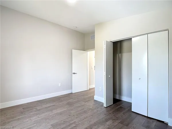 an empty room with wooden floor and closet