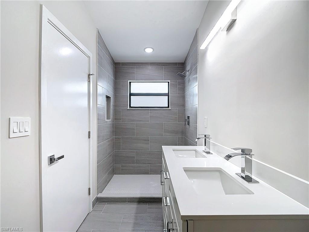 2505 Storter Avenue Naples, FL 34112 - Photo 34 of 49 a bathroom with a sink and a mirror