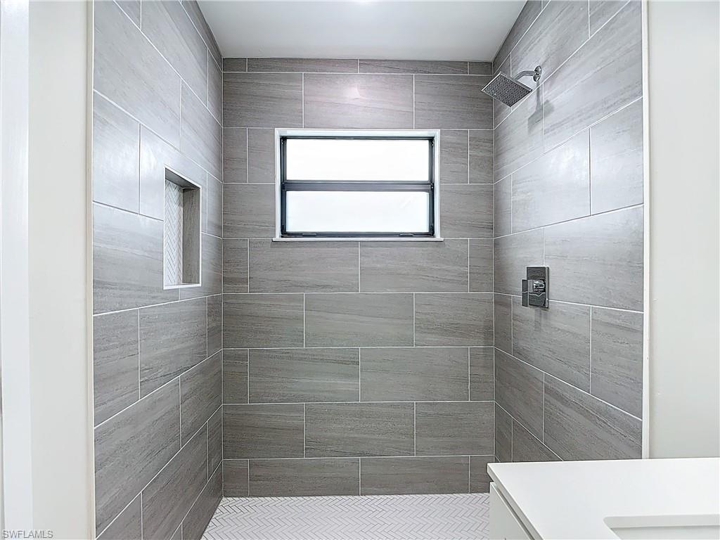 2505 Storter Avenue Naples, FL 34112 - Photo 36 of 49 a bathroom with a window and shower
