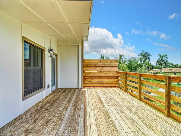a view of a balcony with wooden floor and fence
