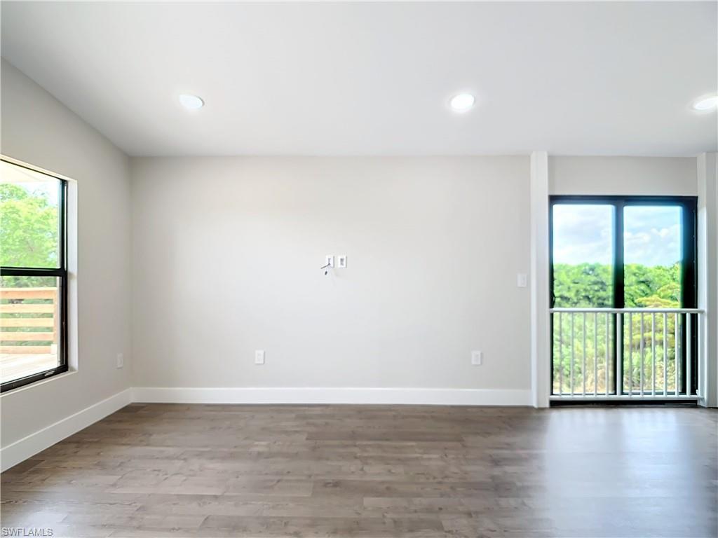 2505 Storter Avenue Naples, FL 34112 - Photo 8 of 49 an empty room with wooden floor and windows