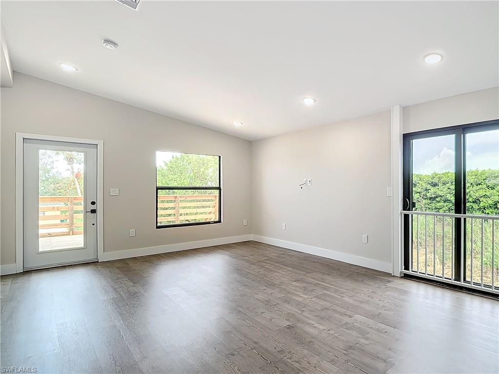2505 Storter Avenue Naples, FL 34112 - Photo 9 of 49 an empty room with wooden floor and windows