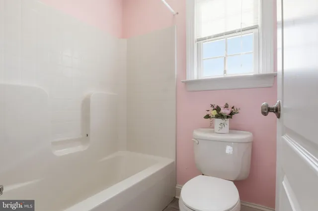 a view of a swimming pool with a yard and large trees