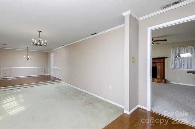 an empty room with windows and ceiling fan