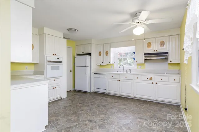 a kitchen with granite countertop white cabinets and stainless steel appliances