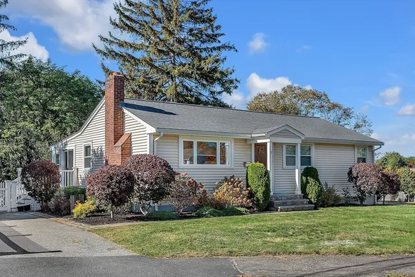 a view of a house with a yard and potted plants