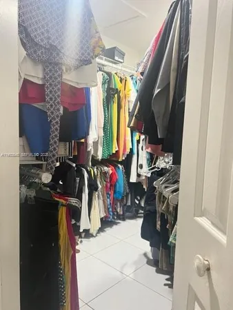 a view of walk in closet with clothes and shoes