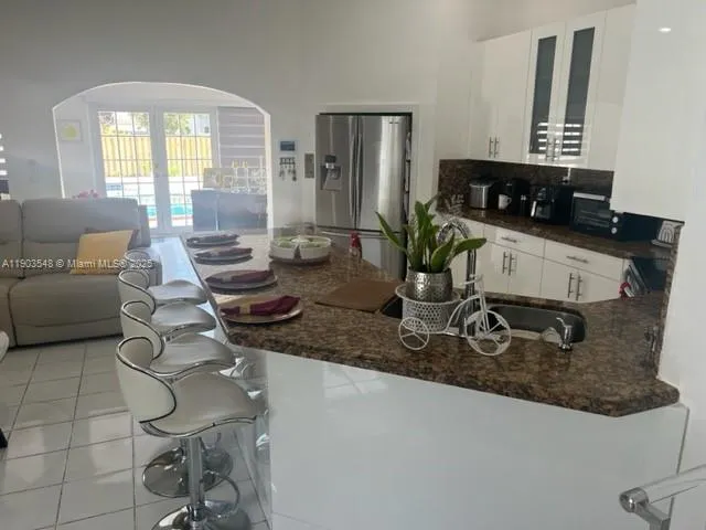 a kitchen with a sink a counter and a couch