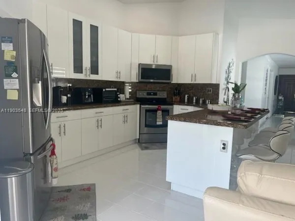 a kitchen with stainless steel appliances a refrigerator sink and white cabinets