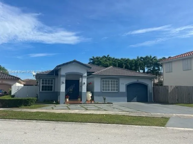 a front view of a house with a garden and yard