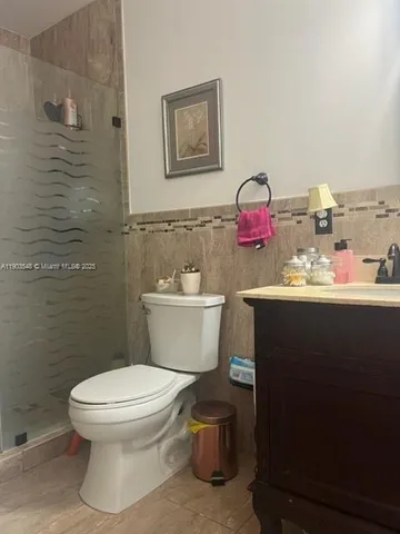 a bathroom with a toilet sink vanity and mirror