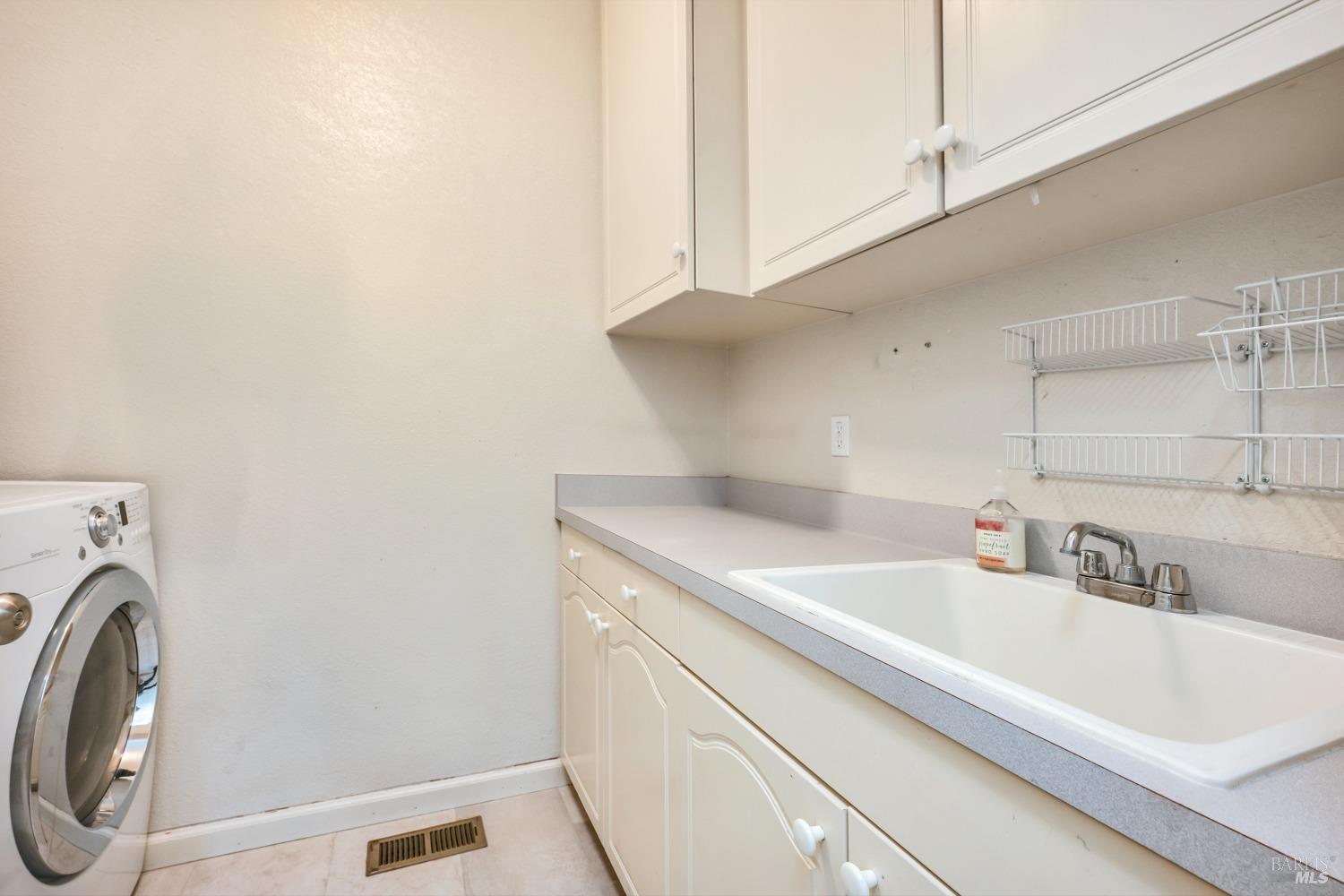 1508 Ronne Drive Santa Rosa, CA 95404 - Photo 41 of 55 a bathroom with a sink and a washer dryer