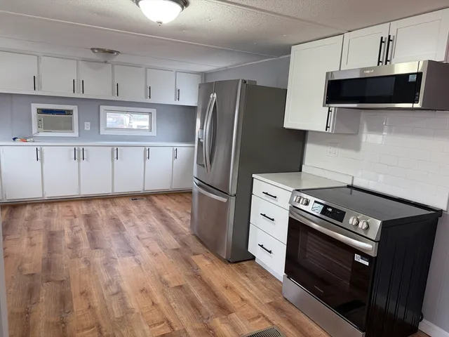 a kitchen with stainless steel appliances a stove a refrigerator and a microwave