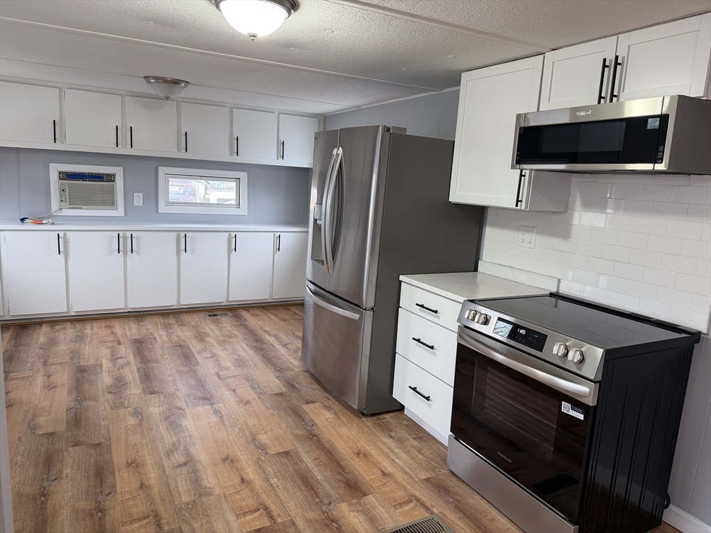 a kitchen with stainless steel appliances a stove a refrigerator and a microwave