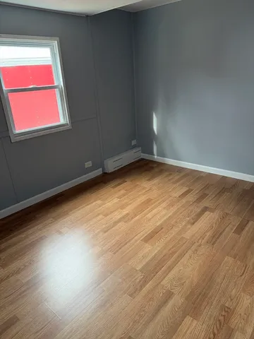 a view of room and hall with wooden floor