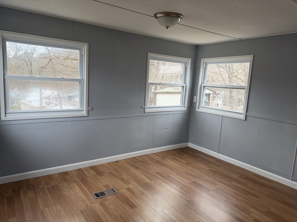 181 Boston Post Road East, Unit 26 Marlborough, MA 01752 - Photo 7 of 14 an empty room with wooden floor and windows