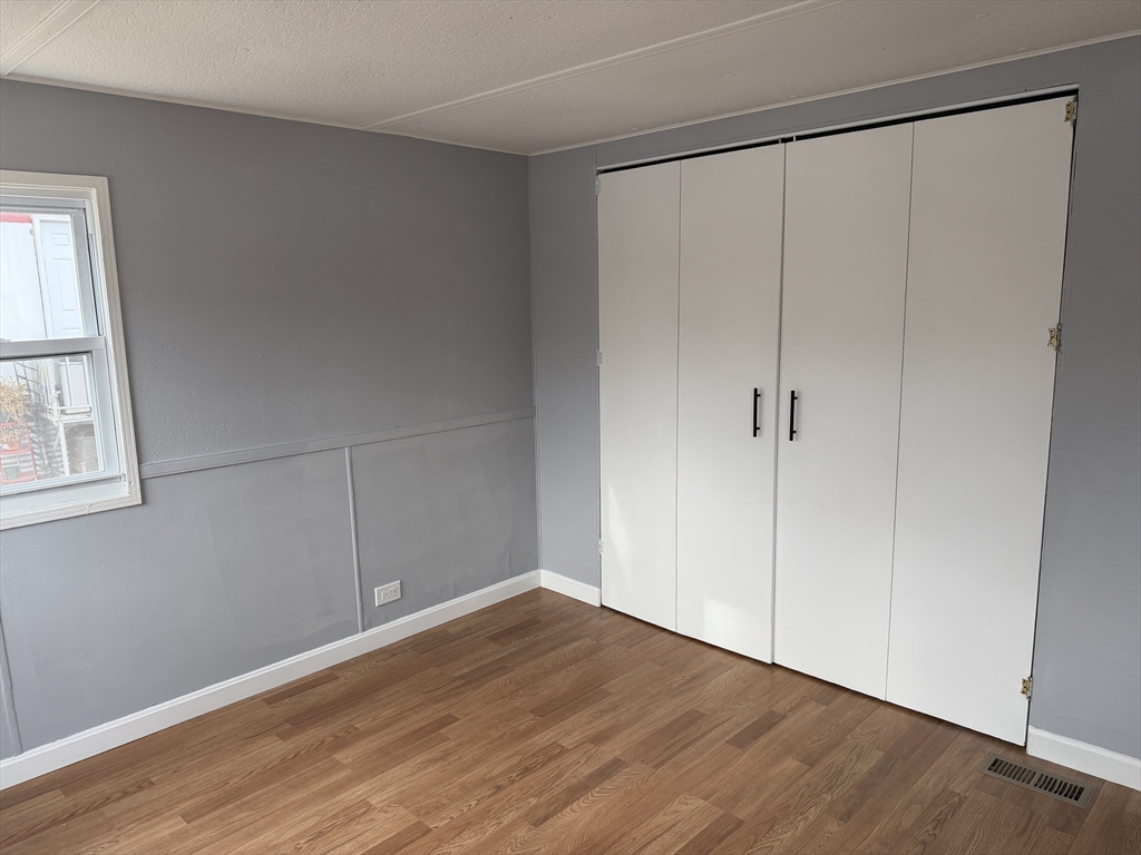 181 Boston Post Road East, Unit 26 Marlborough, MA 01752 - Photo 8 of 14 a view of an empty room with wooden floor