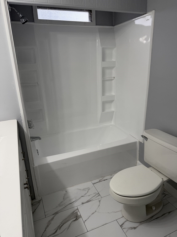 181 Boston Post Road East, Unit 26 Marlborough, MA 01752 - Photo 10 of 14 a white toilet sitting next to a bath tub