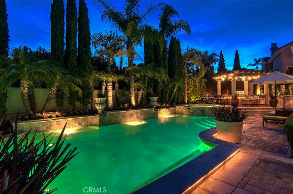 21 Asilomar Road Laguna Niguel, CA 92677 - Photo 30 of 35 a view of a swimming pool with lawn chairs under an umbrella