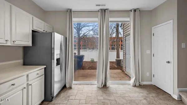 a view of a kitchen with a refrigerator and cabinets