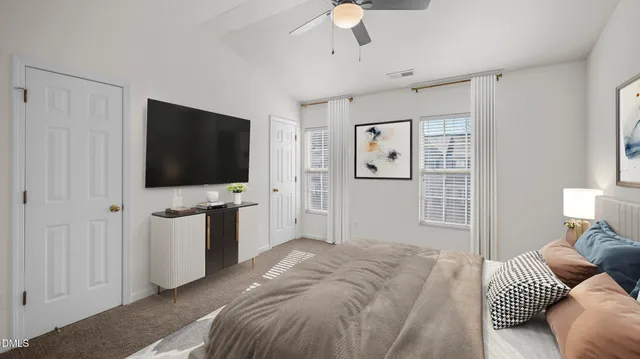 a bedroom with a bed tv and a window