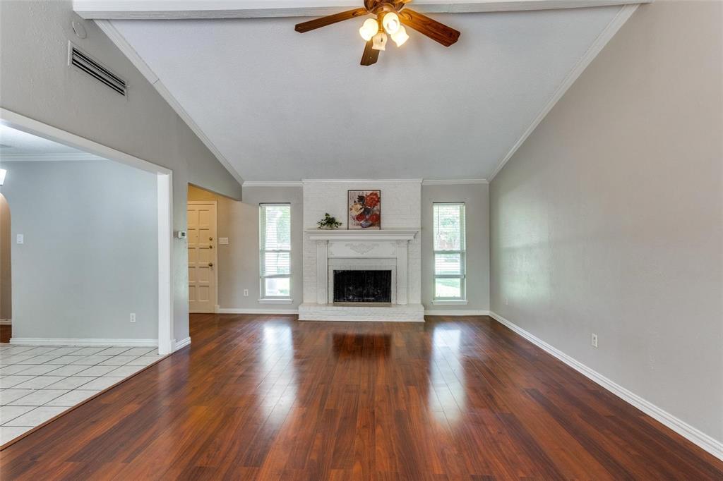 1708 Hendrick Drive Plano, TX 75074 - Photo 3 of 23 a view of an empty room with wooden floor fireplace and a window
