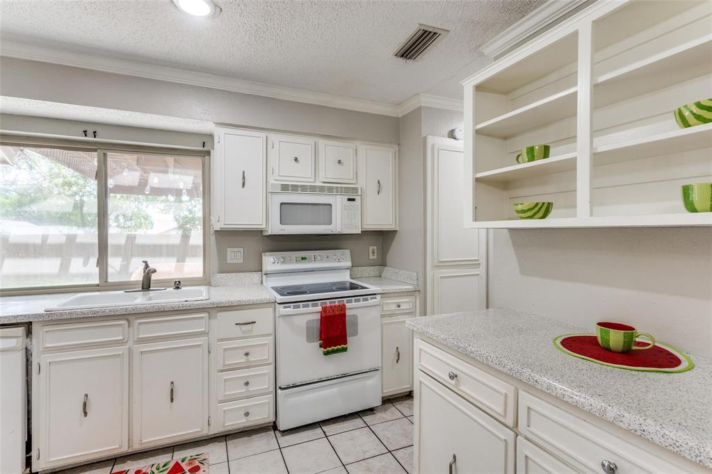 1708 Hendrick Drive Plano, TX 75074 - Photo 9 of 23 a kitchen with white cabinets and white appliances