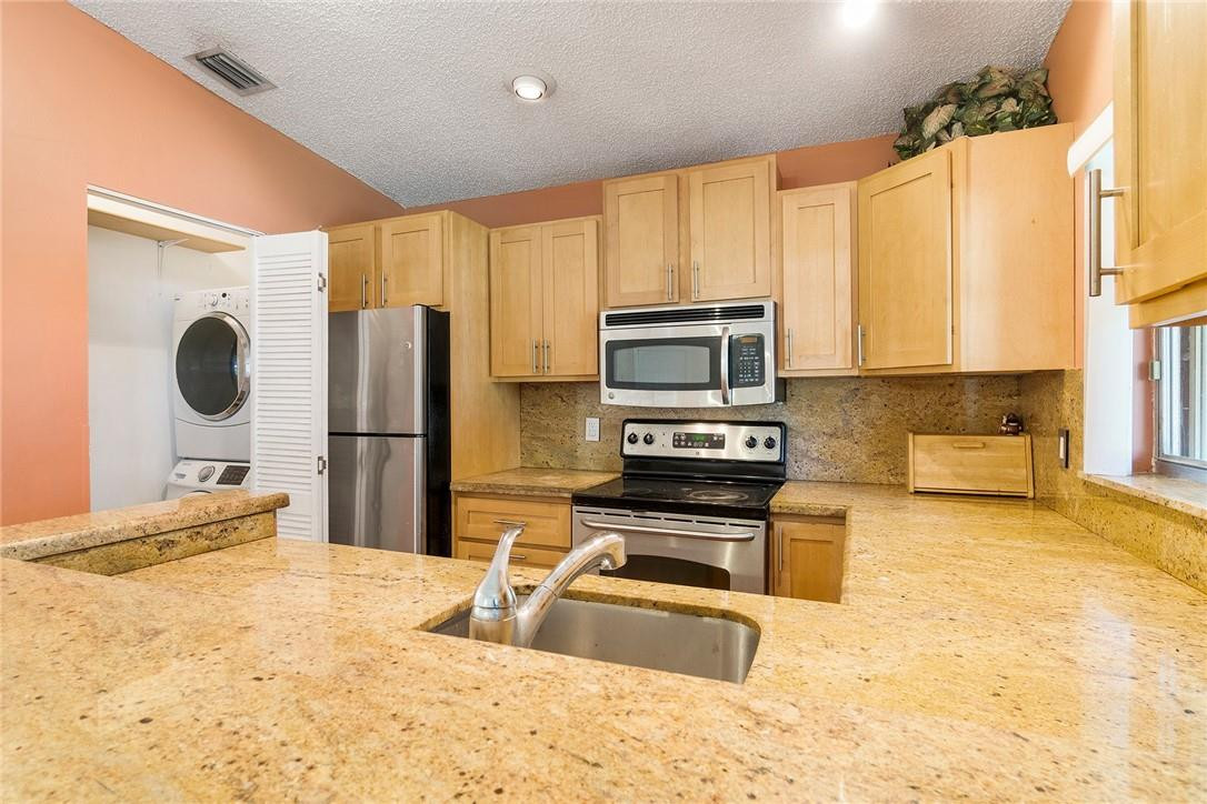 11739 Timbers Way Boca Raton, FL 33428 - Photo 8 of 26 a kitchen with a stove a sink and a refrigerator