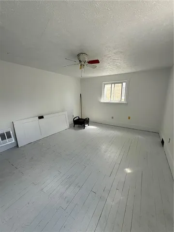 a view of an empty room with window and stairs