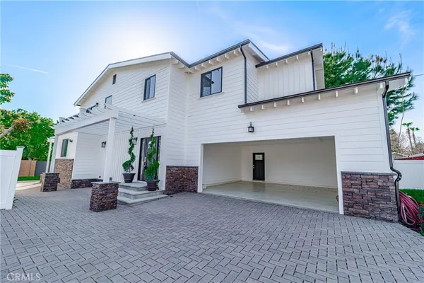 a view of a house with backyard and sitting area