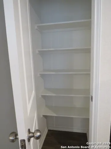a view of walk in closet with empty racks