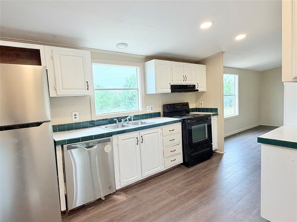 9721 Limestone Joshua, TX 76058 - Photo 16 of 36 a kitchen with granite countertop white cabinets and white appliances