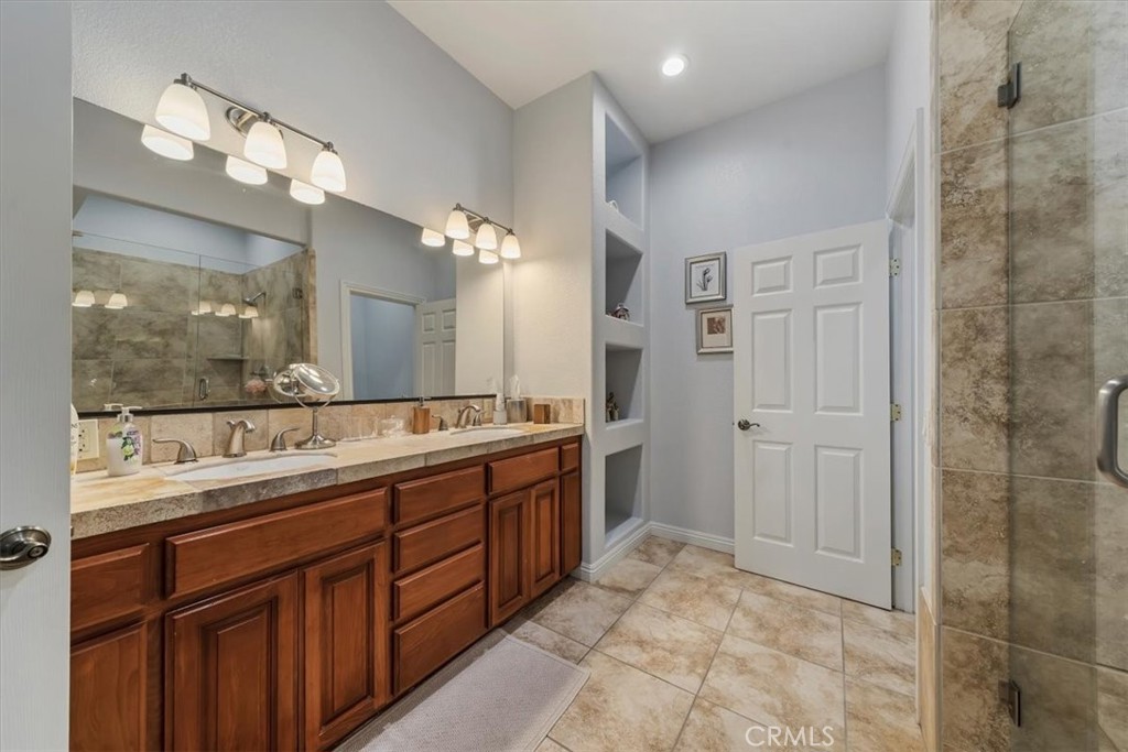 27312 Little Bear Road Lake Arrowhead, CA 92352 - Photo 33 of 47 a spacious bathroom with a granite countertop sink a mirror and a shower