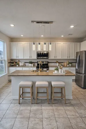 a kitchen with stainless steel appliances granite countertop a stove a sink a microwave and a refrigerator