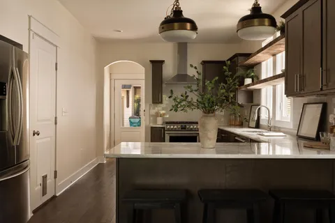 a kitchen with granite countertop a refrigerator stove top oven and sink