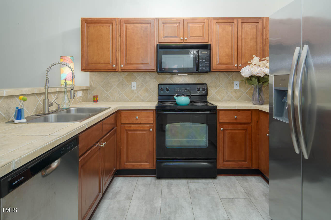 2610 Oldgate Drive, Unit 101 Raleigh, NC 27604 - Photo 13 of 23 a kitchen with stainless steel appliances granite countertop a refrigerator stove and sink