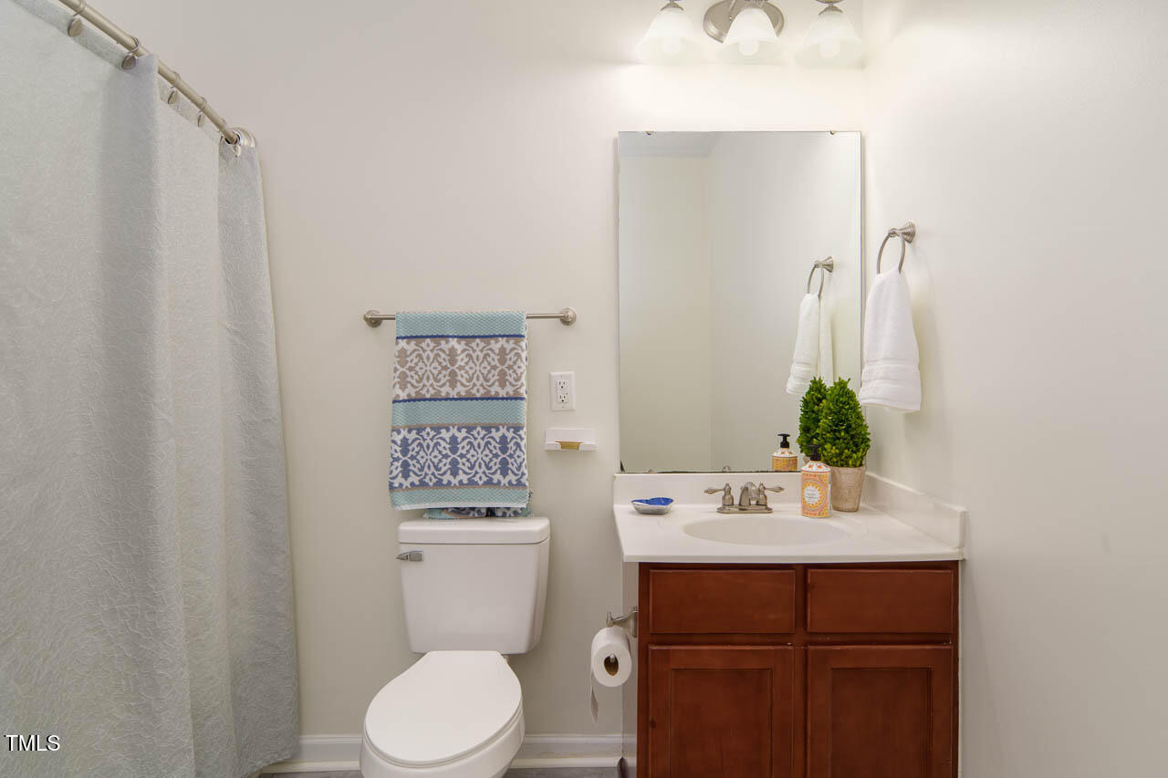 2610 Oldgate Drive, Unit 101 Raleigh, NC 27604 - Photo 18 of 23 a bathroom with a toilet a sink and a mirror