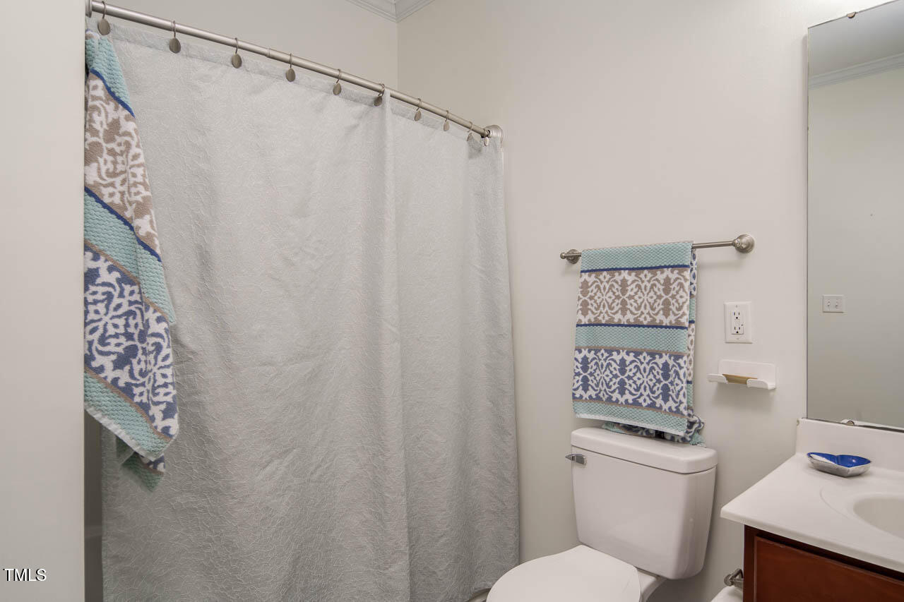 2610 Oldgate Drive, Unit 101 Raleigh, NC 27604 - Photo 19 of 23 a white toilet sitting next to a shower curtain