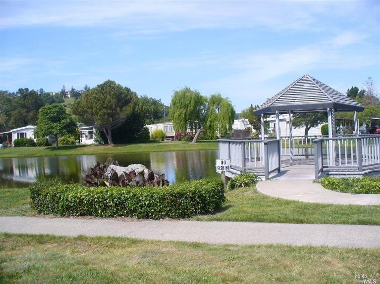 394 Bryce Canyon Road, Unit 394 San Rafael, CA 94903 - Photo 1 of 1 a view of a garden with a bench in a lake