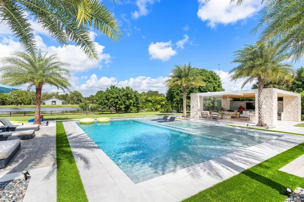 a swimming pool with outdoor seating and garden