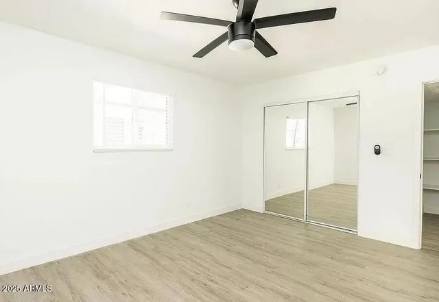 a view of empty room with wooden floor