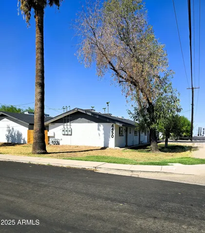 a yellow house with trees in front of it