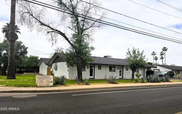 a front view of a house with a garden and plants