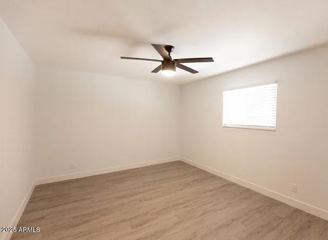 a view of a big room with wooden floor and a ceiling fan