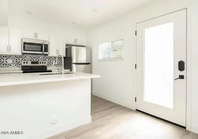 a kitchen with stainless steel appliances a refrigerator and a stove top oven
